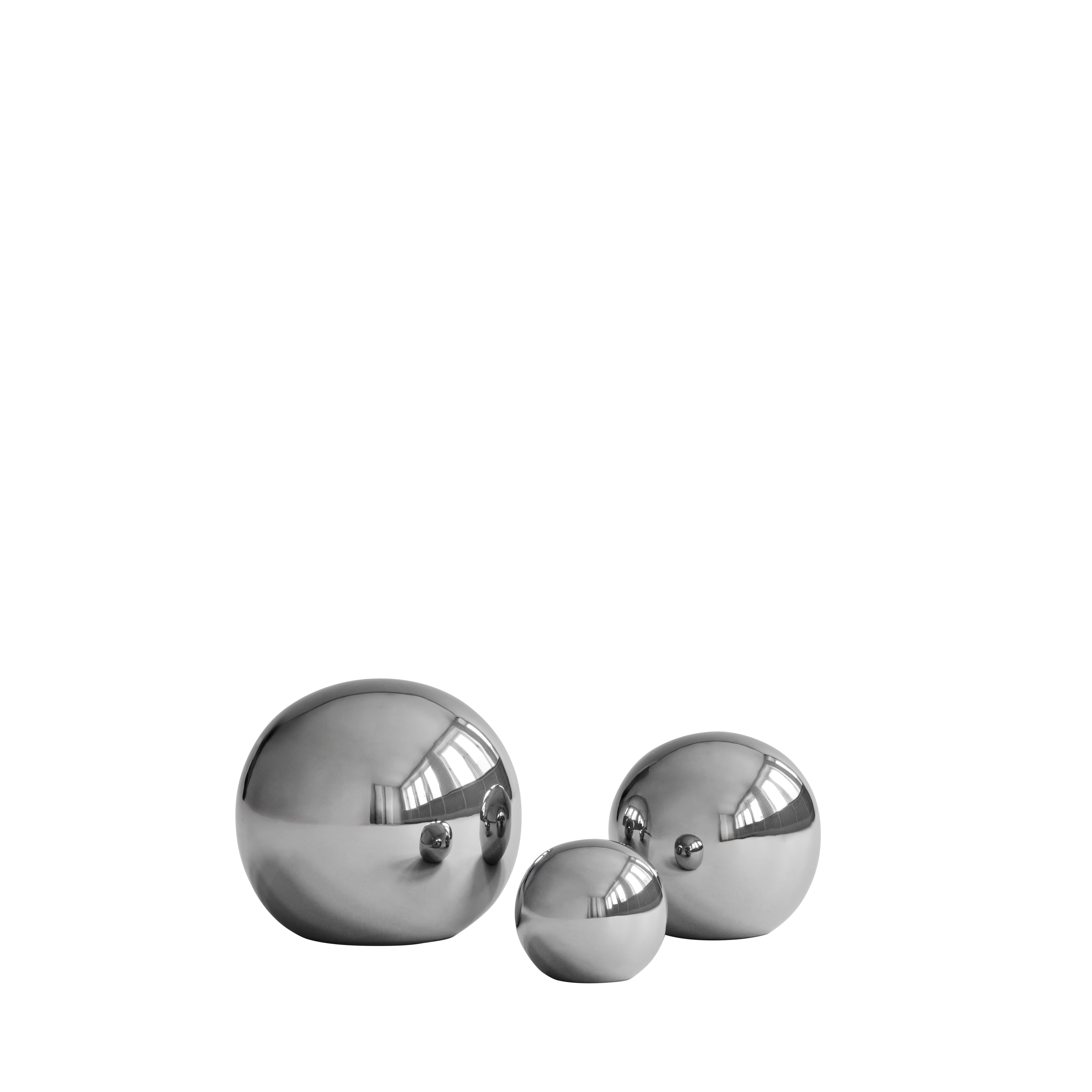 Three chrome balls of different sizes arranged in a row on a white background. The reflective surfaces capture studio light reflections.